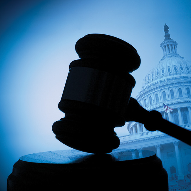 Closeup of a gavel with a government building in the background